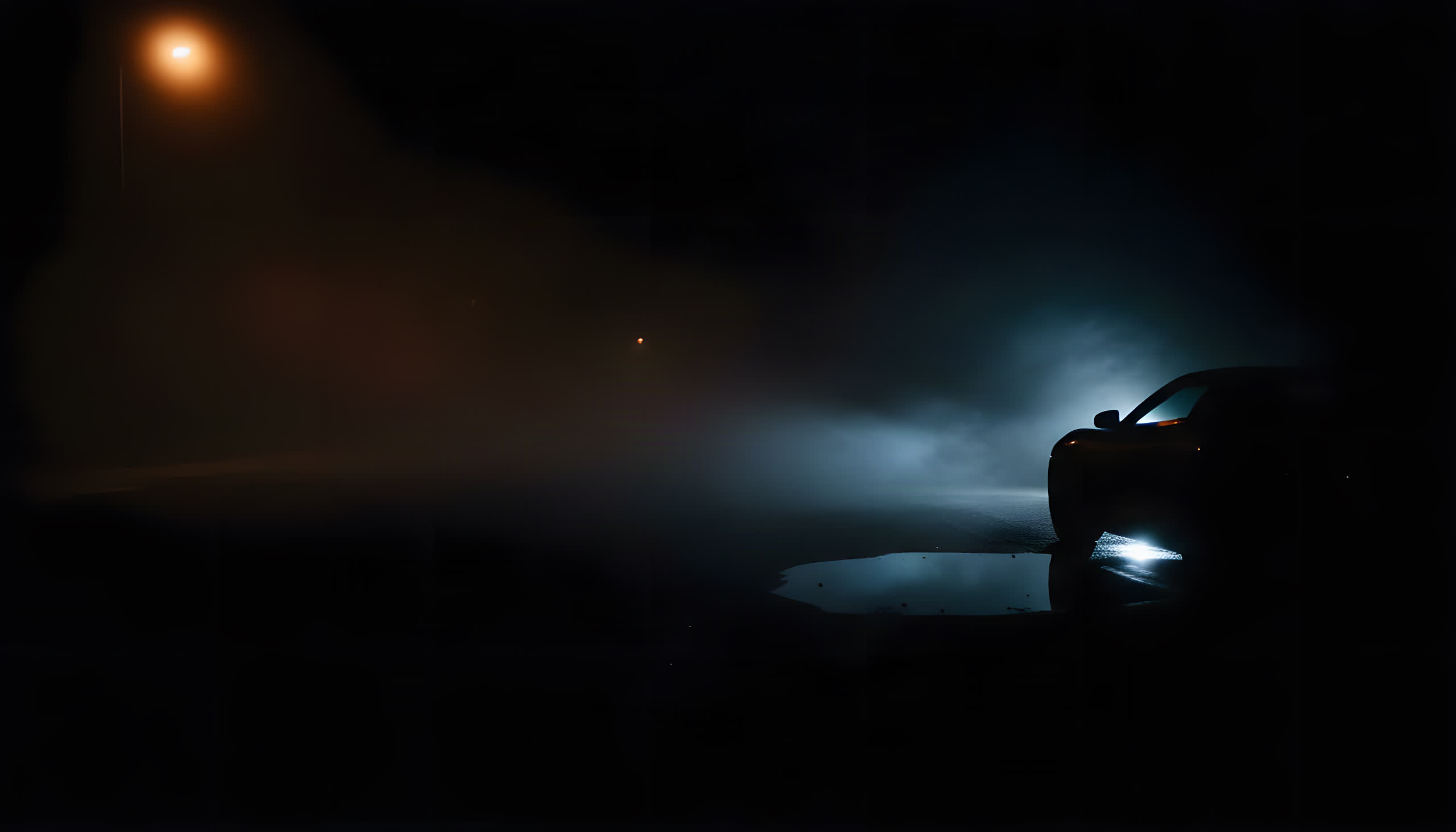 A parked coupe silhouetted in fog under a sodium streetlamp, headlight glow pooling on wet asphalt